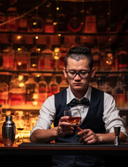 Bartender is pouring whiskey into a glass a customer's glass.	
