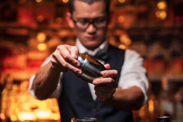 Bartender is pouring whiskey into a glass a customer's glass.