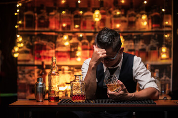 Bartender is pouring whiskey into a glass a customer's glass.