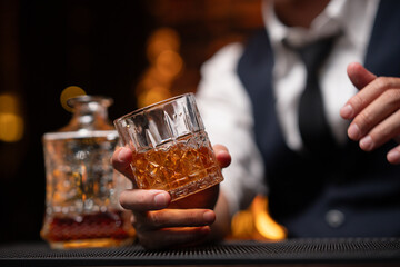 Bartender is pouring whiskey into a glass a customer's glass.	

