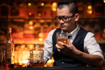 Bartender is pouring whiskey into a glass a customer's glass.	
