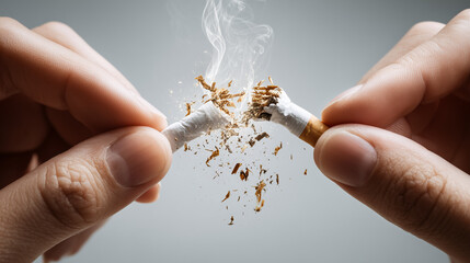 Close up of two hands breaking a cigarette in half, symbol of quitting smoking, health awareness, anti tobacco concept, lifestyle change, addiction prevention, stop smoking message.