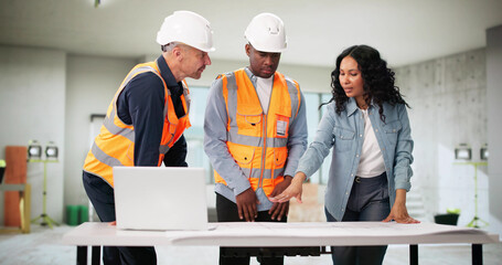 Engineers Inspect Blueprint Of House Remodel With Client