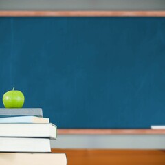 Green apple on pile of books in classroom