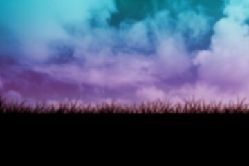 Grassy field against clouds