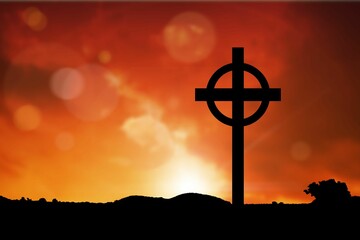 Cross religion symbol shape over sunset sky