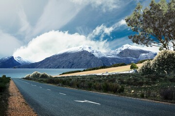 Flat design illustration is showing two-lane asphalt road with white dashed lines running past lake