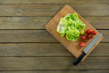 Lettuce and tomatoes on wooden cutting board
