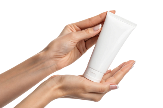 Woman holding a white cosmetic cream tube in her hands with clean manicured nails isolated on transparent background