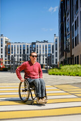 middle aged european man in wheelchair crossing intersection
