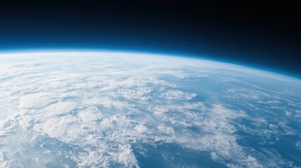 View of Earth's curvature from space, showing the thin blue atmosphere and vast cloud formations over the planet's surface.
