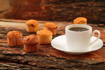 Delicious breakfast- fresh baked muffins and hot coffee served on a rustic wooden table.