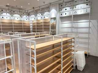 Retail store with fully installed empty white shelve racks and bright lighting before opening or...