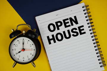 Open House text written on notepad with alarm clock on yellow background