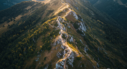Scenic aerial shot of dramatic mountain ridges with a mix of green grass and rocky cliffs, bathed in golden sunlight. Ideal for nature, trekking, or outdoor travel themes.