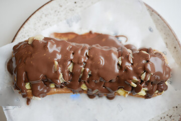 Delicious chocolate-covered pastry with nuts on a plate