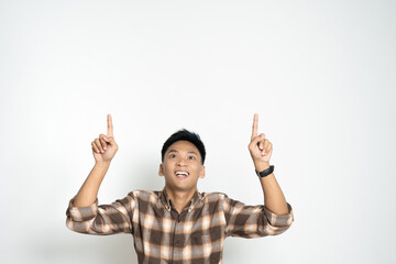 Cheerful young man enthusiastically pointing upwards, showcasing excitement and joy. Ideal image for concepts such as encouragement, positivity, or enthusiasm.