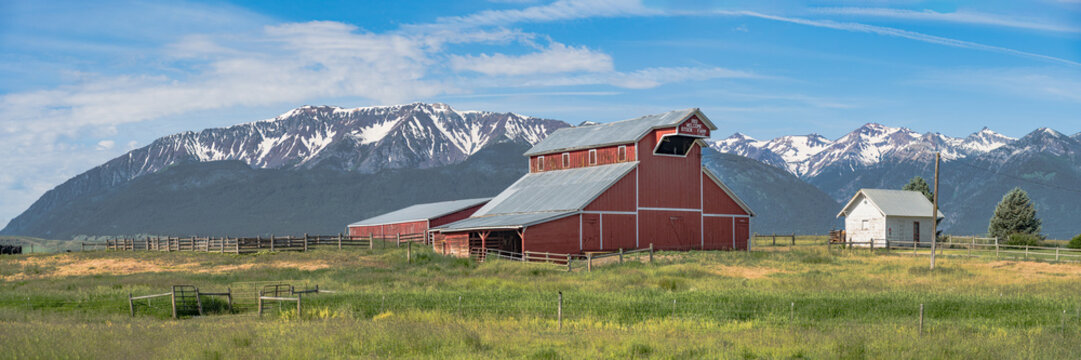 Iconic wooden red barn in Eastern Oregon with the Cascade Mountains in the background