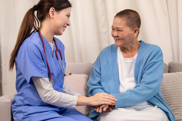 Obraz premium Young female nurse holding hands with senior woman, both smiling with trust and warmth during health support session in cozy home setting, healthcare, caregiver, take care, consult.