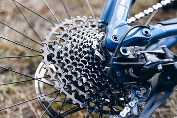 metal cassette of blue high-speed mountain bike, bike lying on ground, bicycle chain parts, close-up image