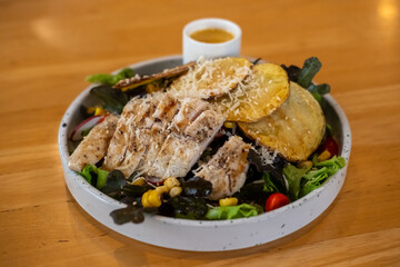 Grilled chicken salad with sauce, on plate for served in a restaurant