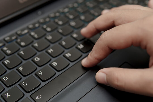 Detailed photographic close-up of a hand typing on laptop keyboard ideal for technology blogs business reports and remote work visuals