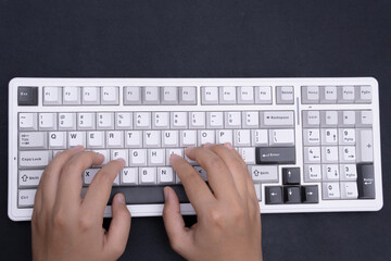 Photographic capture of hands typing on white keyboard for tech articles or productivity blog...