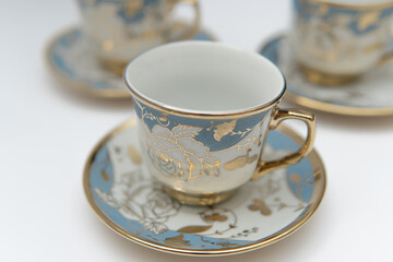 Elegant gold floral teacups photographic still life, photo for lifestyle blogs or vintage decor classic refined aesthetic