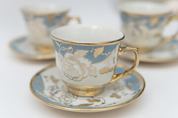 Elegant photographic still life of vintage porcelain teacups with blue and gold floral design suitable for lifestyle imagery and classic decor