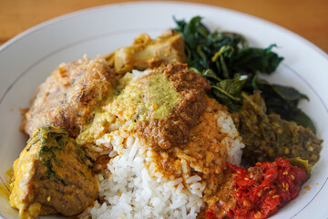 Nasi Padang with Rendang Sauce, Indonesia, captured on June 29, 2025. Traditional Minang rice dish served with rich and spicy rendang sauce, accompanied by vegetables and sambal.