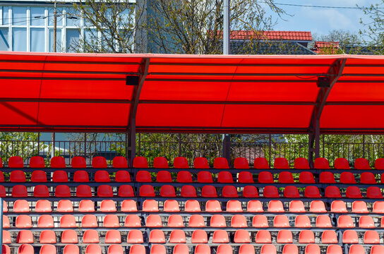 The stadium is empty, with a row of red seats lined up in a row