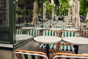 Empty parisian bistro tables and chairs waiting for customers