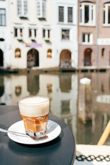 Enjoying a flat white by the canal in Utrecht with beautiful ref