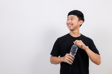 Positive asian man black shirt gesture open water bottle with happy smile look at space isolated