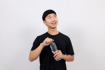 Positive asian man black shirt gesture open water bottle with happy smile look up at space isolated