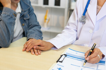 Doctor holding patient hand showing support and care during consultation