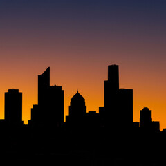 Fototapeta premium Chicago and Los Angeles city skylines at sunset, with urban buildings and skyscrapers silhouetted against the dusk sky