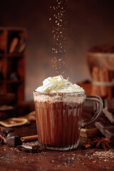 Hot chocolate topped with whipped cream and sprinkled with chocolate chips.