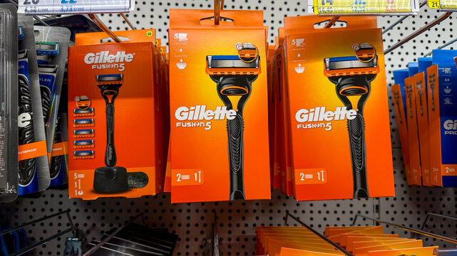 Gillette Fusion 5 razors with blades in orange packaging arranged on retail grooming shelf display