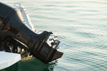 Obraz premium Close-up of outboard motor on modern boat in calm seawater