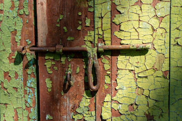 Vintage door latch on cracked green wooden background  
