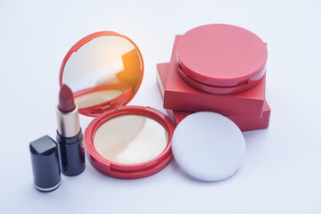 Elegant red compact foudation face powder matching lipstick in black tube, displayed with soft puff...