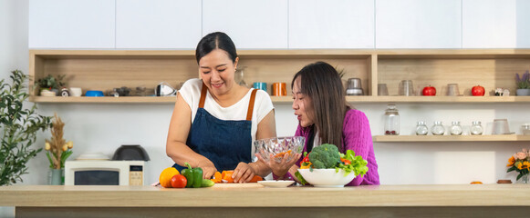 Healthy Cooking Together. Women enjoying vegetable preparation in a bright kitchen.