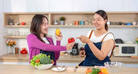 Healthy Cooking and Joyful Moments. Women sharing fresh produce while cooking in a modern kitchen.