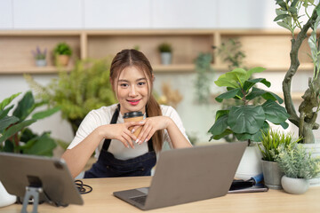 Remote Work and Wellness. Young woman enjoying coffee while working on a laptop.