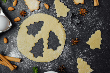 Holiday cookie dough and almond baking setup with festive decor and spices for christmas culinary theme