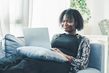Business, working, technology, Black woman freelancer smiling while using laptop at home, relaxed...