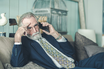 Senior businessman in formal shirt holding smartphone, appearing stressed during phone call lay off...