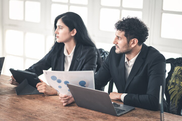 Obraz premium Caucasian Hispanic man discussing work with woman at office desk. male and female working together. Business interaction, teamwork, or small business couple strategic planning work at home office