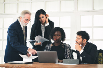 Group of multiethnic businessman entrepreneur and senior manager male conference in meeting room at workplace, employees brainstorming discussing business strategy planning using laptop technology